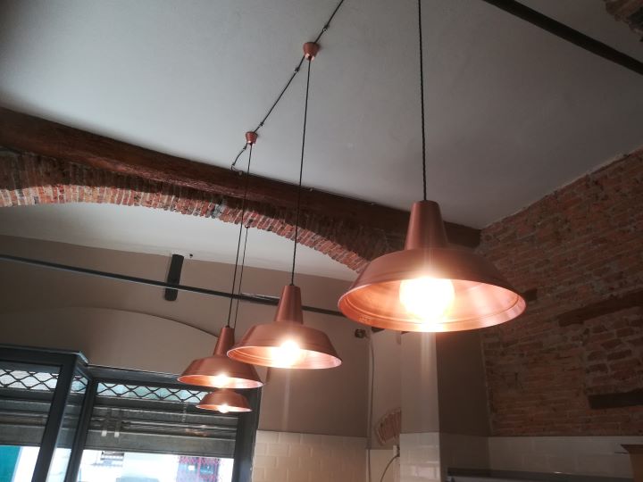 Lampade a sospensione in rame collegate con cavo a treccia adatto ad ambiente rustico